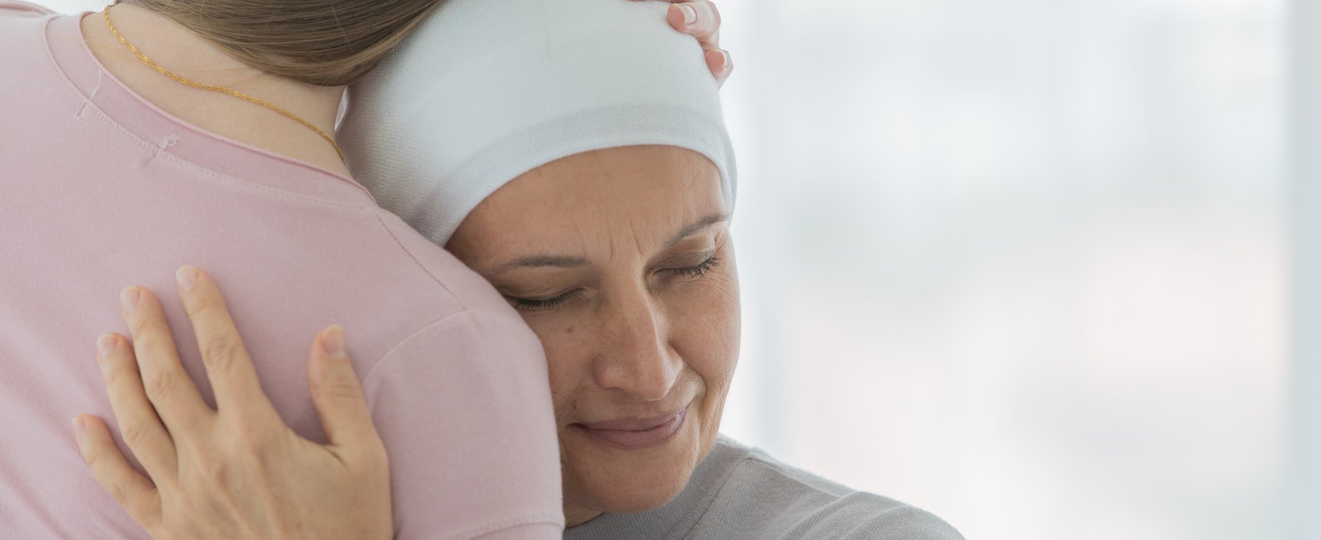 Eine Frau trägt ein Tuch um den Kopf und umarmt ein Kind