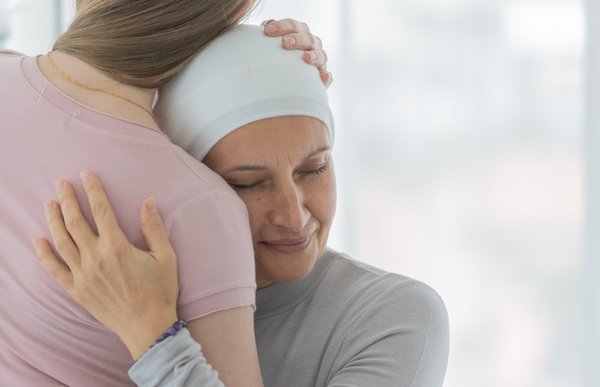 Eine Frau trägt ein Tuch um den Kopf und umarmt ein Kind