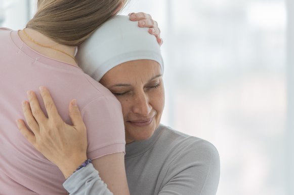 Eine Frau trägt ein Tuch um den Kopf und umarmt ein Kind