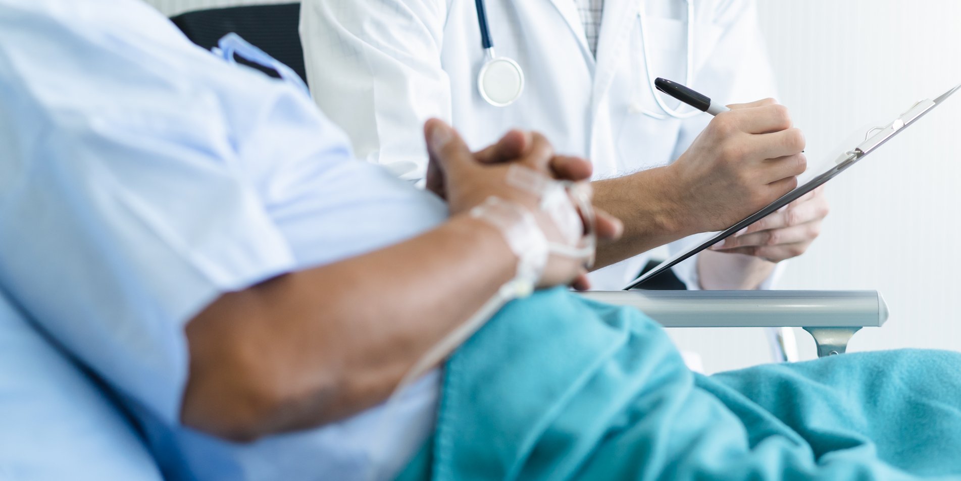 Arzt spricht mit einem Patienten am Krankenbett