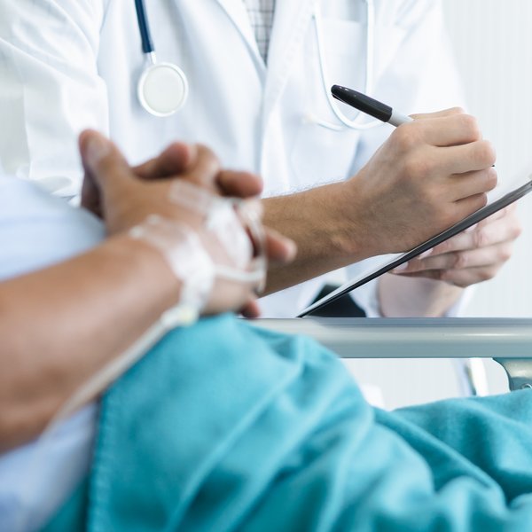 Arzt spricht mit einem Patienten am Krankenbett