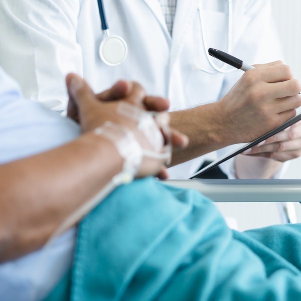 Arzt spricht mit einem Patienten am Krankenbett