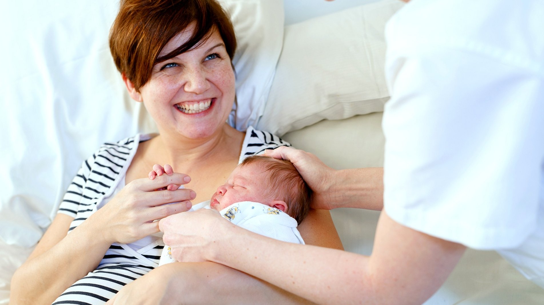 Eine Mutter hält ihr Neugeborenes auf dem Arm