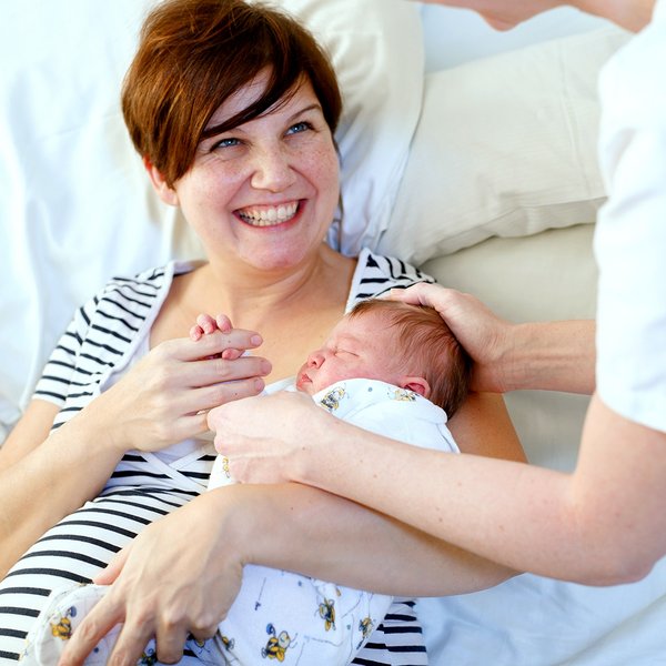 Eine Mutter hält ihr Neugeborenes auf dem Arm