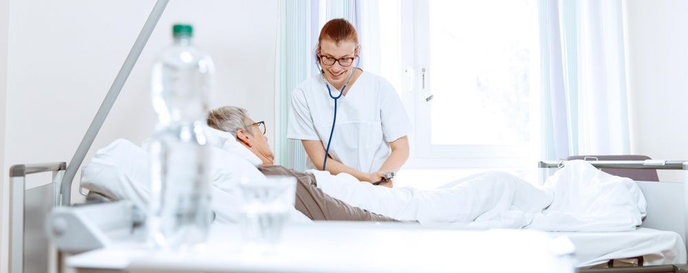 Pflegemitarbeiterin am Patientenbett