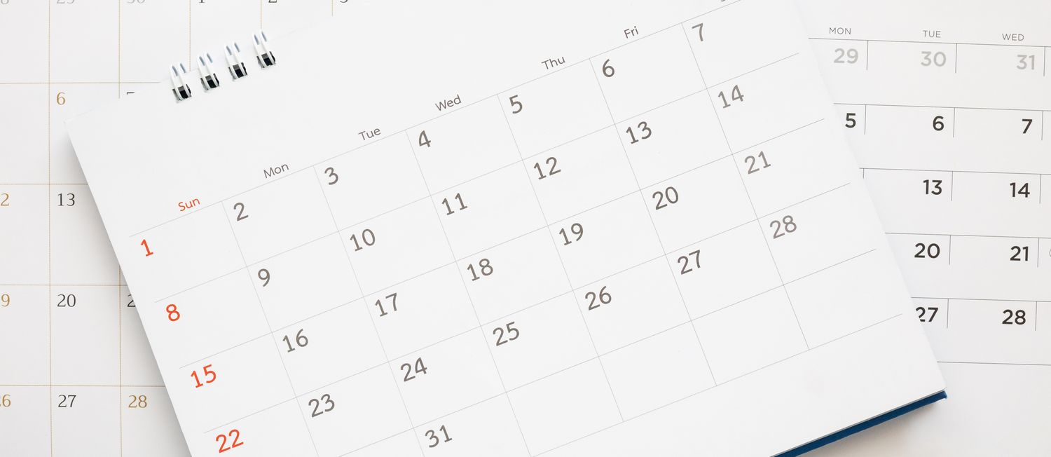 calendar page close up on blue background business planning appointment meeting concept