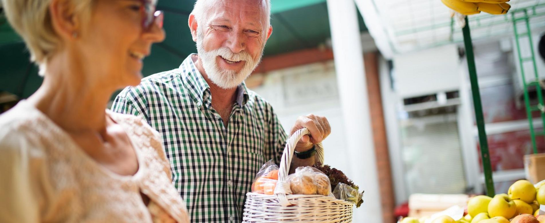 Frau und Mann kaufen auf dem Markt ein