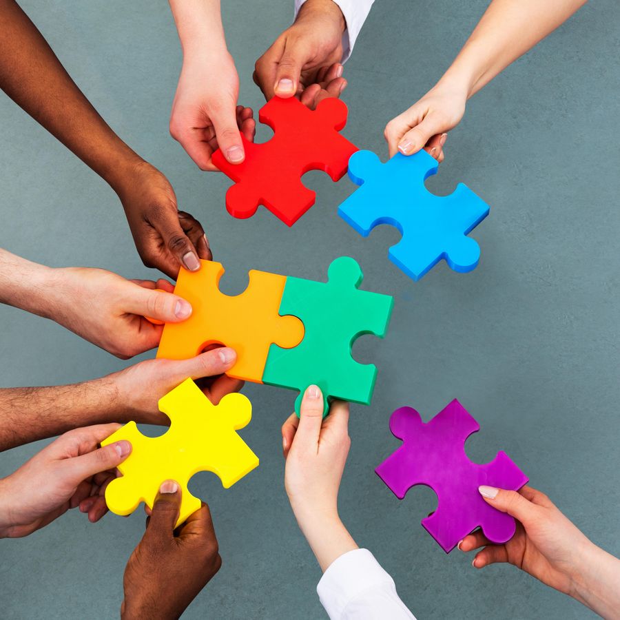 High Angle View Of Medical Team Solving Jigsaw Puzzle